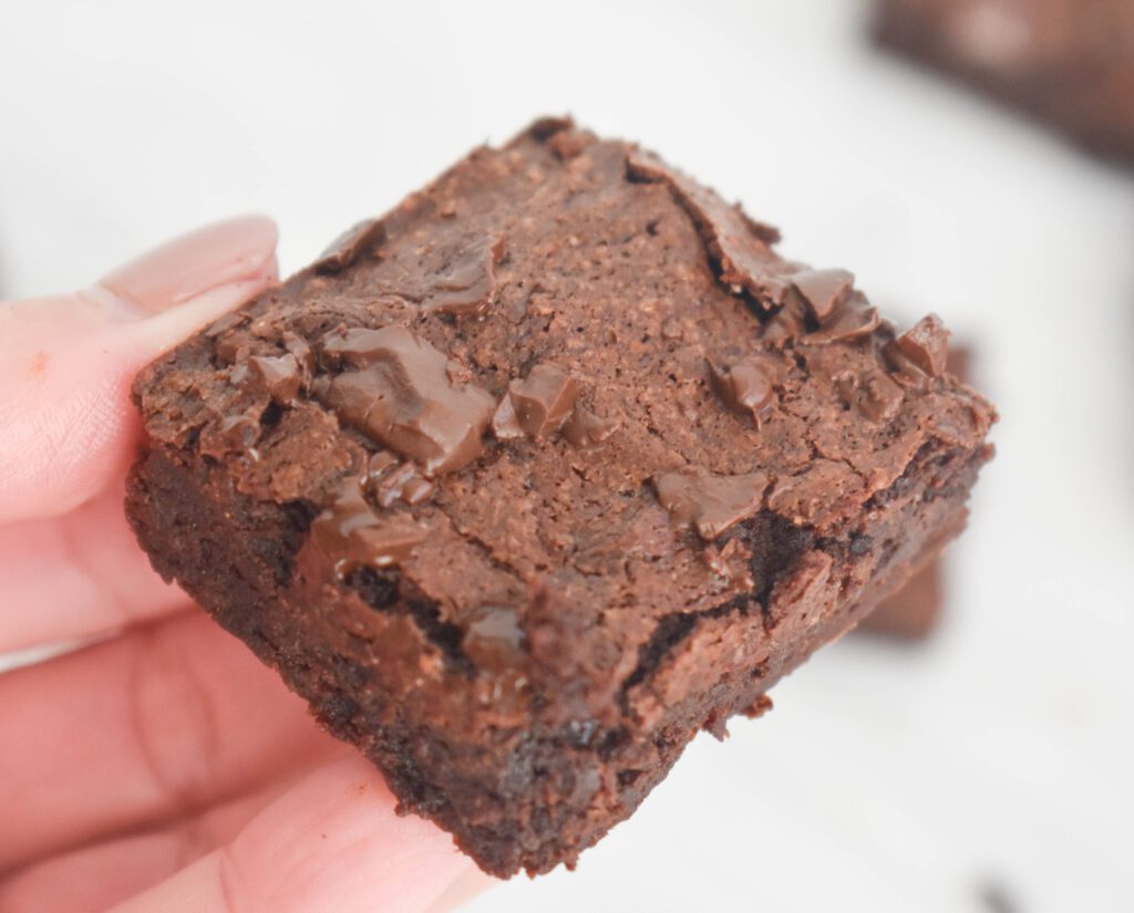 low fodmap flourless brownie in hand